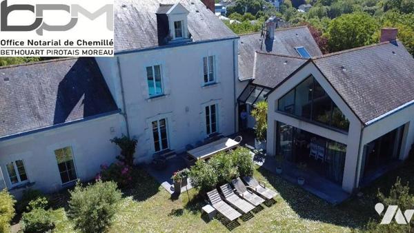 A Mûrs-Érigné, cette propriété de caractère et de charme, clos de murs, offre un cadre de vie e...