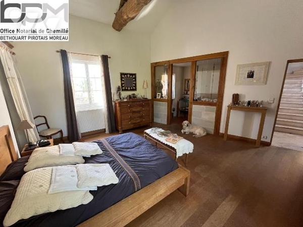 A Mûrs-Érigné, cette propriété de caractère et de charme, clos de murs, offre un cadre de vie e...