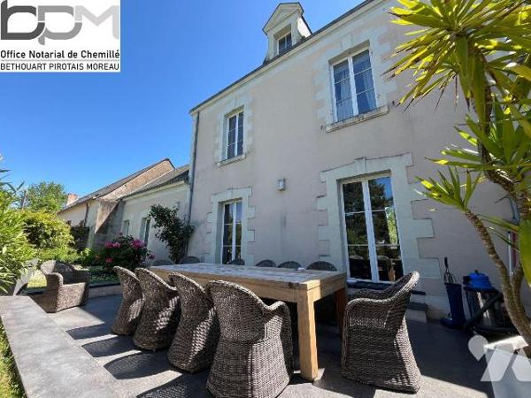 A Mûrs-Érigné, cette propriété de caractère et de charme, clos de murs, offre un cadre de vie e...