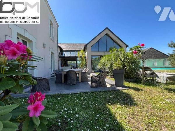 A Mûrs-Érigné, cette propriété de caractère et de charme, clos de murs, offre un cadre de vie e...