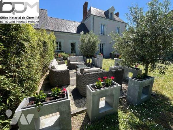 A Mûrs-Érigné, cette propriété de caractère et de charme, clos de murs, offre un cadre de vie e...