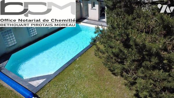 A Mûrs-Érigné, cette propriété de caractère et de charme, clos de murs, offre un cadre de vie e...