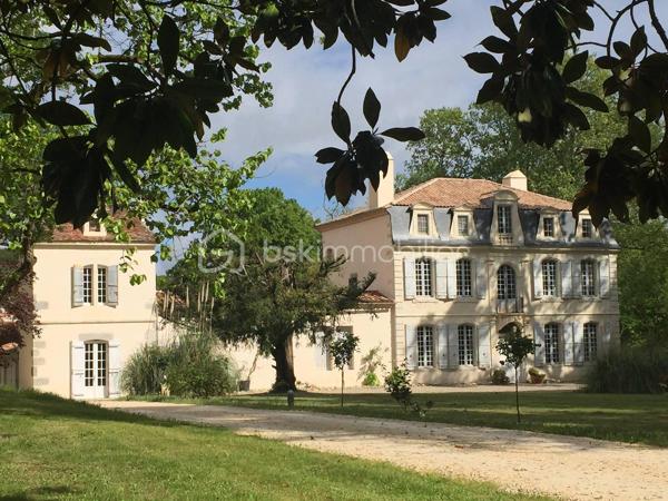 ÉLÉGANCE, HISTOIRE ET NATURE… UN DOMAINE D'EXCEPTION AU CŒUR DU LOT-ET-GARONNE

À seulement 45 minutes d'Agen, entre Bordeaux et Toulouse, se dévoile une propriété rare où le temps semble suspendu.

Au bout d'une majestueuse allée bordée de pins parasols, un parc de près de 4 hectares mêlant bois, prairie, vallon et source naturelle entoure un remarquable ensemble immobilier composé d'un logis du XVIIIᵉ siècle, d'un pavillon du XVIᵉ siècle et de nombreuses dépendances.

Dès l'entrée, le charme opère. Escalier monumental en pierre, cheminées d'époque, boiseries, parquets anciens, tomettes et volumes généreux témoignent du caractère authentique de cette demeure. Les pièces de réception baignées de lumière, la bibliothèque, les cuisines et les nombreuses chambres offrent un cadre de vie chaleureux et prestigieux.

Le pavillon indépendant, entièrement rénové, dispose de deux chambres avec salles d'eau privatives, d'une cuisine équipée, de beaux espaces de vie ainsi que d'un bureau installé dans une authentique tour en pierre. Un espace idéal pour accueillir famille, amis, une activité libérale ou développer un projet touristique.

Les anciennes écuries, le garage et les dépendances laissent entrevoir un potentiel remarquable pour la création de gîtes, d'espaces de réception ou d'un lieu dédié à l'événementiel.

De nombreux travaux structurels ont déjà été réalisés : réfection des toitures, micro-station récente, drainage périphérique, réseaux d'eau et d'électricité modernisés, permettant aux futurs propriétaires de poursuivre la rénovation dans les meilleures conditions.

Cette propriété séduira les passionnés de patrimoine en quête d'une résidence de caractère, mais aussi les investisseurs souhaitant développer une activité d'accueil haut de gamme, de chambres d'hôtes, de séminaires ou de mariages.

Un lieu chargé d'histoire, offrant un cadre naturel exceptionnel et un potentiel rare, où chaque pierre raconte plusieurs siècles d'histoire.

Une visite suffit pour comprendre que cette propriété ne ressemble à aucune autre.