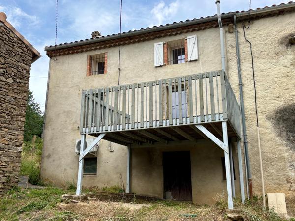 Maison à rénover avec garage, terrasse et parcelle de terrain.
