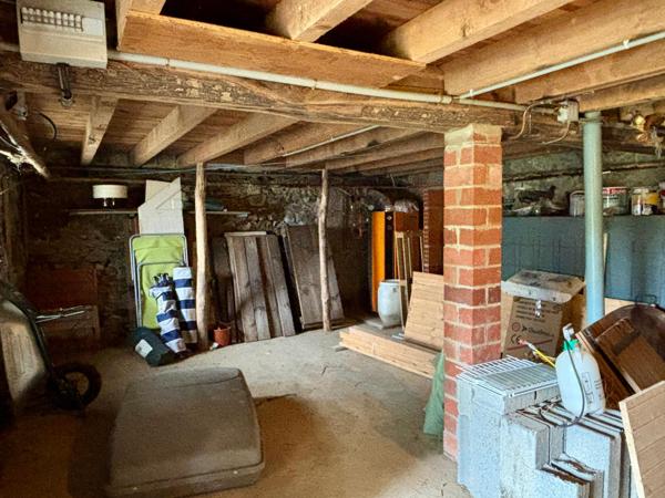 Maison à rénover avec garage, terrasse et parcelle de terrain.