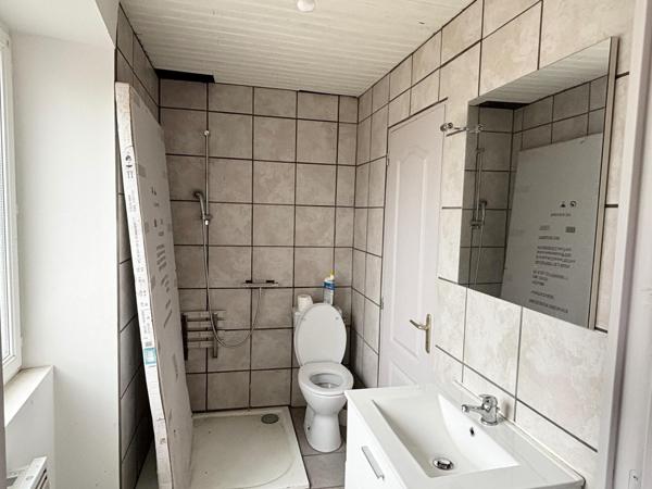 Maison à rénover avec garage, terrasse et parcelle de terrain.