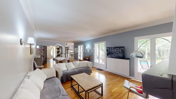 Nichée dans un quartier calme et très prisé aux portes de Bourges, cette grande maison familiale est une véritable invitation à la sérénité. Au cœur d'un magnifique parc de plus de 3 000 m², ses chênes majestueux créent une véritable canopée naturelle. En période de fortes chaleurs, ce formidable écran végétal vous garantit une fraîcheur salvatrice et une ombre bienfaitrice. Ces mêmes arbres constituent également un bouclier naturel, protégeant idéalement la propriété des vents forts tout au long de l'année pour un confort absolu, parfaitement à l'abri des regards.

Dès l'entrée, laissez-vous séduire par des volumes généreux et une belle luminosité. La vaste pièce de réception, réchauffée par un parquet massif et une cheminée, s'ouvre naturellement vers l'extérieur. De larges portes-fenêtres vous guident vers de belles terrasses en bois et l'espace détente, parfaits pour profiter des douces journées à l'ombre de vos arbres. La grande cuisine équipée, véritable lieu de convivialité avec son îlot central, communique directement avec les extérieurs.

Pensée pour le confort de tous, la maison offre une véritable vie de plain-pied grâce à une élégante suite parentale (comprenant une salle d'eau contemporaine et un vaste dressing) ainsi qu'un bureau.

À l'étage, l'espace nuit se révèle être un véritable cocon : quatre belles chambres offrant des vues apaisantes et dégagées sur le feuillage du jardin, ainsi qu'une grande salle de jeux qui fera le bonheur des enfants ou pourra accueillir vos passions.

Un sous-sol total (grand garage, atelier, cave) et des aménagements extérieurs pratiques (vaste carport idéal pour un camping-car, portail électrique) viennent parfaire les prestations de cette propriété. Le confort intérieur est également assuré par un système de chauffage écologique et performant aux granulés.

Un véritable havre de paix et de fraîcheur, aux espaces parfaitement optimisés, prêt à accueillir votre histoire de famille.

Une visite virtuelle détaillée est disponible sur demande pour découvrir les charmes de cette maison en immersion depuis chez vous, avant de programmer une visite sur place.