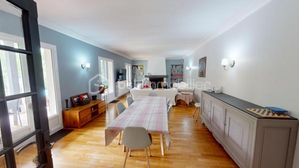 Nichée dans un quartier calme et très prisé aux portes de Bourges, cette grande maison familiale est une véritable invitation à la sérénité. Au cœur d'un magnifique parc de plus de 3 000 m², ses chênes majestueux créent une véritable canopée naturelle. En période de fortes chaleurs, ce formidable écran végétal vous garantit une fraîcheur salvatrice et une ombre bienfaitrice. Ces mêmes arbres constituent également un bouclier naturel, protégeant idéalement la propriété des vents forts tout au long de l'année pour un confort absolu, parfaitement à l'abri des regards.

Dès l'entrée, laissez-vous séduire par des volumes généreux et une belle luminosité. La vaste pièce de réception, réchauffée par un parquet massif et une cheminée, s'ouvre naturellement vers l'extérieur. De larges portes-fenêtres vous guident vers de belles terrasses en bois et l'espace détente, parfaits pour profiter des douces journées à l'ombre de vos arbres. La grande cuisine équipée, véritable lieu de convivialité avec son îlot central, communique directement avec les extérieurs.

Pensée pour le confort de tous, la maison offre une véritable vie de plain-pied grâce à une élégante suite parentale (comprenant une salle d'eau contemporaine et un vaste dressing) ainsi qu'un bureau.

À l'étage, l'espace nuit se révèle être un véritable cocon : quatre belles chambres offrant des vues apaisantes et dégagées sur le feuillage du jardin, ainsi qu'une grande salle de jeux qui fera le bonheur des enfants ou pourra accueillir vos passions.

Un sous-sol total (grand garage, atelier, cave) et des aménagements extérieurs pratiques (vaste carport idéal pour un camping-car, portail électrique) viennent parfaire les prestations de cette propriété. Le confort intérieur est également assuré par un système de chauffage écologique et performant aux granulés.

Un véritable havre de paix et de fraîcheur, aux espaces parfaitement optimisés, prêt à accueillir votre histoire de famille.

Une visite virtuelle détaillée est disponible sur demande pour découvrir les charmes de cette maison en immersion depuis chez vous, avant de programmer une visite sur place.