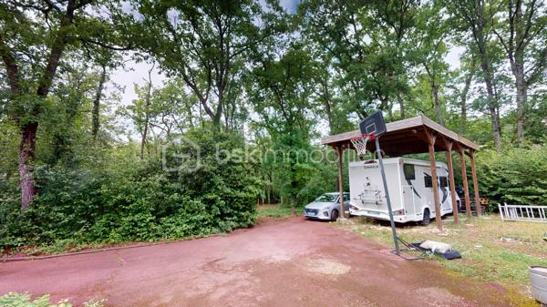 Nichée dans un quartier calme et très prisé aux portes de Bourges, cette grande maison familiale est une véritable invitation à la sérénité. Au cœur d'un magnifique parc de plus de 3 000 m², ses chênes majestueux créent une véritable canopée naturelle. En période de fortes chaleurs, ce formidable écran végétal vous garantit une fraîcheur salvatrice et une ombre bienfaitrice. Ces mêmes arbres constituent également un bouclier naturel, protégeant idéalement la propriété des vents forts tout au long de l'année pour un confort absolu, parfaitement à l'abri des regards.

Dès l'entrée, laissez-vous séduire par des volumes généreux et une belle luminosité. La vaste pièce de réception, réchauffée par un parquet massif et une cheminée, s'ouvre naturellement vers l'extérieur. De larges portes-fenêtres vous guident vers de belles terrasses en bois et l'espace détente, parfaits pour profiter des douces journées à l'ombre de vos arbres. La grande cuisine équipée, véritable lieu de convivialité avec son îlot central, communique directement avec les extérieurs.

Pensée pour le confort de tous, la maison offre une véritable vie de plain-pied grâce à une élégante suite parentale (comprenant une salle d'eau contemporaine et un vaste dressing) ainsi qu'un bureau.

À l'étage, l'espace nuit se révèle être un véritable cocon : quatre belles chambres offrant des vues apaisantes et dégagées sur le feuillage du jardin, ainsi qu'une grande salle de jeux qui fera le bonheur des enfants ou pourra accueillir vos passions.

Un sous-sol total (grand garage, atelier, cave) et des aménagements extérieurs pratiques (vaste carport idéal pour un camping-car, portail électrique) viennent parfaire les prestations de cette propriété. Le confort intérieur est également assuré par un système de chauffage écologique et performant aux granulés.

Un véritable havre de paix et de fraîcheur, aux espaces parfaitement optimisés, prêt à accueillir votre histoire de famille.

Une visite virtuelle détaillée est disponible sur demande pour découvrir les charmes de cette maison en immersion depuis chez vous, avant de programmer une visite sur place.