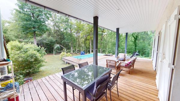 Nichée dans un quartier calme et très prisé aux portes de Bourges, cette grande maison familiale est une véritable invitation à la sérénité. Au cœur d'un magnifique parc de plus de 3 000 m², ses chênes majestueux créent une véritable canopée naturelle. En période de fortes chaleurs, ce formidable écran végétal vous garantit une fraîcheur salvatrice et une ombre bienfaitrice. Ces mêmes arbres constituent également un bouclier naturel, protégeant idéalement la propriété des vents forts tout au long de l'année pour un confort absolu, parfaitement à l'abri des regards.

Dès l'entrée, laissez-vous séduire par des volumes généreux et une belle luminosité. La vaste pièce de réception, réchauffée par un parquet massif et une cheminée, s'ouvre naturellement vers l'extérieur. De larges portes-fenêtres vous guident vers de belles terrasses en bois et l'espace détente, parfaits pour profiter des douces journées à l'ombre de vos arbres. La grande cuisine équipée, véritable lieu de convivialité avec son îlot central, communique directement avec les extérieurs.

Pensée pour le confort de tous, la maison offre une véritable vie de plain-pied grâce à une élégante suite parentale (comprenant une salle d'eau contemporaine et un vaste dressing) ainsi qu'un bureau.

À l'étage, l'espace nuit se révèle être un véritable cocon : quatre belles chambres offrant des vues apaisantes et dégagées sur le feuillage du jardin, ainsi qu'une grande salle de jeux qui fera le bonheur des enfants ou pourra accueillir vos passions.

Un sous-sol total (grand garage, atelier, cave) et des aménagements extérieurs pratiques (vaste carport idéal pour un camping-car, portail électrique) viennent parfaire les prestations de cette propriété. Le confort intérieur est également assuré par un système de chauffage écologique et performant aux granulés.

Un véritable havre de paix et de fraîcheur, aux espaces parfaitement optimisés, prêt à accueillir votre histoire de famille.

Une visite virtuelle détaillée est disponible sur demande pour découvrir les charmes de cette maison en immersion depuis chez vous, avant de programmer une visite sur place.