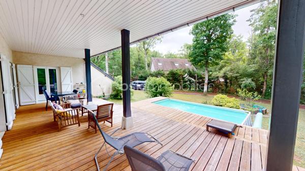Nichée dans un quartier calme et très prisé aux portes de Bourges, cette grande maison familiale est une véritable invitation à la sérénité. Au cœur d'un magnifique parc de plus de 3 000 m², ses chênes majestueux créent une véritable canopée naturelle. En période de fortes chaleurs, ce formidable écran végétal vous garantit une fraîcheur salvatrice et une ombre bienfaitrice. Ces mêmes arbres constituent également un bouclier naturel, protégeant idéalement la propriété des vents forts tout au long de l'année pour un confort absolu, parfaitement à l'abri des regards.

Dès l'entrée, laissez-vous séduire par des volumes généreux et une belle luminosité. La vaste pièce de réception, réchauffée par un parquet massif et une cheminée, s'ouvre naturellement vers l'extérieur. De larges portes-fenêtres vous guident vers de belles terrasses en bois et l'espace détente, parfaits pour profiter des douces journées à l'ombre de vos arbres. La grande cuisine équipée, véritable lieu de convivialité avec son îlot central, communique directement avec les extérieurs.

Pensée pour le confort de tous, la maison offre une véritable vie de plain-pied grâce à une élégante suite parentale (comprenant une salle d'eau contemporaine et un vaste dressing) ainsi qu'un bureau.

À l'étage, l'espace nuit se révèle être un véritable cocon : quatre belles chambres offrant des vues apaisantes et dégagées sur le feuillage du jardin, ainsi qu'une grande salle de jeux qui fera le bonheur des enfants ou pourra accueillir vos passions.

Un sous-sol total (grand garage, atelier, cave) et des aménagements extérieurs pratiques (vaste carport idéal pour un camping-car, portail électrique) viennent parfaire les prestations de cette propriété. Le confort intérieur est également assuré par un système de chauffage écologique et performant aux granulés.

Un véritable havre de paix et de fraîcheur, aux espaces parfaitement optimisés, prêt à accueillir votre histoire de famille.

Une visite virtuelle détaillée est disponible sur demande pour découvrir les charmes de cette maison en immersion depuis chez vous, avant de programmer une visite sur place.