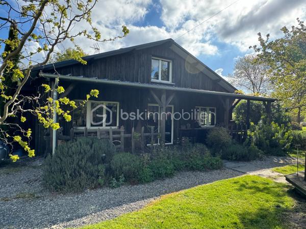 Rare à la vente, cet atelier d'artiste aménagé en maison d'habitation offre un beau potentiel à ses futurs propriétaires. 
Amoureux du bois et de la nature, ce "chalet" est fait pour vous ! Contrairement à ce que l'on pourrait penser, la structure de la maison n'est pas en bois mais en parpaing et a été enduite à la chaux. Ensuite un bardage bois a été posé. 
S'il reste aujourd'hui un atelier de peinture de 28m2 dans lequel vous pourriez aisément aussi y faire un bureau, une salle de sport, une salle de jeux ou un garage, 105m2 sont prêts à accueillir votre famille. 
Nous commencerons la visite par la pièce de vie de 45m2 qui comprend le salon-séjour et la cuisine. Une magnifique véranda chauffée "jardin d'hiver" complète cette maison, idéale pour y installer une grande table familiale ou encore un salon. 
Nous poursuivrons la visite du rez-de-chaussée avec une salle d'eau de 6m2, une chambre de 11m2. 
A l'étage, deux chambres de 12m2 au sol dont une donne accès à la "tour". 
Le mode de chauffage principal est un poêle à bois et radiateurs électriques dans la véranda et l'atelier. La maison consomme peu, le DPE est en C. 
Toutes les menuiseries sont en double vitrage. 
Coté rangement, belle surprise avec le sous-sol de 75m2, vous pourrez y stocker vélos, motos, outils et aisément un coin bricolage si vous le souhaitez. Pas de voiture possible. 
Une microstation a été installée. La toiture est en bac acier. 
Coté extérieur, vous pourrez profitez sans aucun vis à vis de la parcelle de 3300m2 partiellement close et joliment arborée et agrémentée tant par ses terrasses bois que par le bassin à poissons avec sa fontaine. 
Vous aimez le jardin, deux serres sont en place. 
La maison se situe aux portes de la Bretagne, à deux minutes de l'axe Laval-Rennes. 
Alors vous aussi vous aimez cette maison-atelier ? Appelez-moi pour plus de renseignements et peut-être fixer une visite !