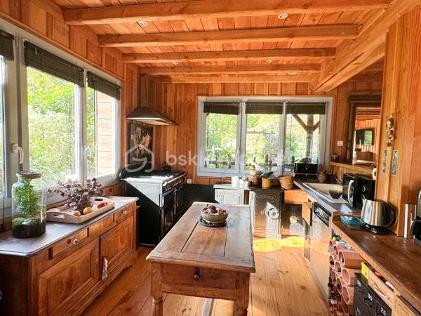 Rare à la vente, cet atelier d'artiste aménagé en maison d'habitation offre un beau potentiel à ses futurs propriétaires. 
Amoureux du bois et de la nature, ce "chalet" est fait pour vous ! Contrairement à ce que l'on pourrait penser, la structure de la maison n'est pas en bois mais en parpaing et a été enduite à la chaux. Ensuite un bardage bois a été posé. 
S'il reste aujourd'hui un atelier de peinture de 28m2 dans lequel vous pourriez aisément aussi y faire un bureau, une salle de sport, une salle de jeux ou un garage, 105m2 sont prêts à accueillir votre famille. 
Nous commencerons la visite par la pièce de vie de 45m2 qui comprend le salon-séjour et la cuisine. Une magnifique véranda chauffée "jardin d'hiver" complète cette maison, idéale pour y installer une grande table familiale ou encore un salon. 
Nous poursuivrons la visite du rez-de-chaussée avec une salle d'eau de 6m2, une chambre de 11m2. 
A l'étage, deux chambres de 12m2 au sol dont une donne accès à la "tour". 
Le mode de chauffage principal est un poêle à bois et radiateurs électriques dans la véranda et l'atelier. La maison consomme peu, le DPE est en C. 
Toutes les menuiseries sont en double vitrage. 
Coté rangement, belle surprise avec le sous-sol de 75m2, vous pourrez y stocker vélos, motos, outils et aisément un coin bricolage si vous le souhaitez. Pas de voiture possible. 
Une microstation a été installée. La toiture est en bac acier. 
Coté extérieur, vous pourrez profitez sans aucun vis à vis de la parcelle de 3300m2 partiellement close et joliment arborée et agrémentée tant par ses terrasses bois que par le bassin à poissons avec sa fontaine. 
Vous aimez le jardin, deux serres sont en place. 
La maison se situe aux portes de la Bretagne, à deux minutes de l'axe Laval-Rennes. 
Alors vous aussi vous aimez cette maison-atelier ? Appelez-moi pour plus de renseignements et peut-être fixer une visite !