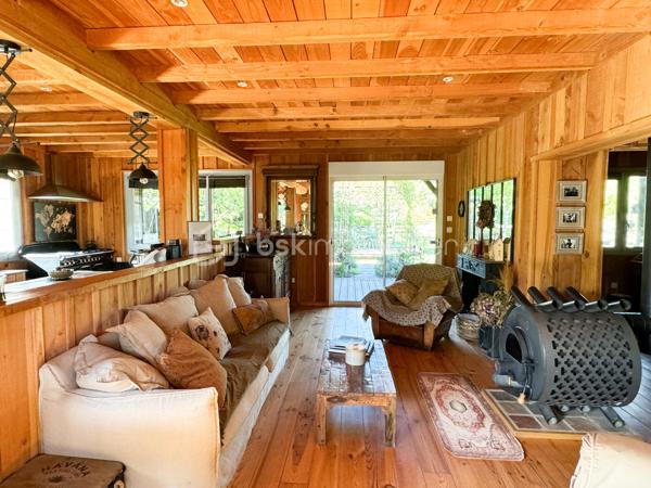 Rare à la vente, cet atelier d'artiste aménagé en maison d'habitation offre un beau potentiel à ses futurs propriétaires. 
Amoureux du bois et de la nature, ce "chalet" est fait pour vous ! Contrairement à ce que l'on pourrait penser, la structure de la maison n'est pas en bois mais en parpaing et a été enduite à la chaux. Ensuite un bardage bois a été posé. 
S'il reste aujourd'hui un atelier de peinture de 28m2 dans lequel vous pourriez aisément aussi y faire un bureau, une salle de sport, une salle de jeux ou un garage, 105m2 sont prêts à accueillir votre famille. 
Nous commencerons la visite par la pièce de vie de 45m2 qui comprend le salon-séjour et la cuisine. Une magnifique véranda chauffée "jardin d'hiver" complète cette maison, idéale pour y installer une grande table familiale ou encore un salon. 
Nous poursuivrons la visite du rez-de-chaussée avec une salle d'eau de 6m2, une chambre de 11m2. 
A l'étage, deux chambres de 12m2 au sol dont une donne accès à la "tour". 
Le mode de chauffage principal est un poêle à bois et radiateurs électriques dans la véranda et l'atelier. La maison consomme peu, le DPE est en C. 
Toutes les menuiseries sont en double vitrage. 
Coté rangement, belle surprise avec le sous-sol de 75m2, vous pourrez y stocker vélos, motos, outils et aisément un coin bricolage si vous le souhaitez. Pas de voiture possible. 
Une microstation a été installée. La toiture est en bac acier. 
Coté extérieur, vous pourrez profitez sans aucun vis à vis de la parcelle de 3300m2 partiellement close et joliment arborée et agrémentée tant par ses terrasses bois que par le bassin à poissons avec sa fontaine. 
Vous aimez le jardin, deux serres sont en place. 
La maison se situe aux portes de la Bretagne, à deux minutes de l'axe Laval-Rennes. 
Alors vous aussi vous aimez cette maison-atelier ? Appelez-moi pour plus de renseignements et peut-être fixer une visite !