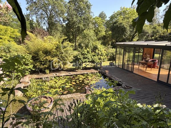 Rare à la vente, cet atelier d'artiste aménagé en maison d'habitation offre un beau potentiel à ses futurs propriétaires. 
Amoureux du bois et de la nature, ce "chalet" est fait pour vous ! Contrairement à ce que l'on pourrait penser, la structure de la maison n'est pas en bois mais en parpaing et a été enduite à la chaux. Ensuite un bardage bois a été posé. 
S'il reste aujourd'hui un atelier de peinture de 28m2 dans lequel vous pourriez aisément aussi y faire un bureau, une salle de sport, une salle de jeux ou un garage, 105m2 sont prêts à accueillir votre famille. 
Nous commencerons la visite par la pièce de vie de 45m2 qui comprend le salon-séjour et la cuisine. Une magnifique véranda chauffée "jardin d'hiver" complète cette maison, idéale pour y installer une grande table familiale ou encore un salon. 
Nous poursuivrons la visite du rez-de-chaussée avec une salle d'eau de 6m2, une chambre de 11m2. 
A l'étage, deux chambres de 12m2 au sol dont une donne accès à la "tour". 
Le mode de chauffage principal est un poêle à bois et radiateurs électriques dans la véranda et l'atelier. La maison consomme peu, le DPE est en C. 
Toutes les menuiseries sont en double vitrage. 
Coté rangement, belle surprise avec le sous-sol de 75m2, vous pourrez y stocker vélos, motos, outils et aisément un coin bricolage si vous le souhaitez. Pas de voiture possible. 
Une microstation a été installée. La toiture est en bac acier. 
Coté extérieur, vous pourrez profitez sans aucun vis à vis de la parcelle de 3300m2 partiellement close et joliment arborée et agrémentée tant par ses terrasses bois que par le bassin à poissons avec sa fontaine. 
Vous aimez le jardin, deux serres sont en place. 
La maison se situe aux portes de la Bretagne, à deux minutes de l'axe Laval-Rennes. 
Alors vous aussi vous aimez cette maison-atelier ? Appelez-moi pour plus de renseignements et peut-être fixer une visite !