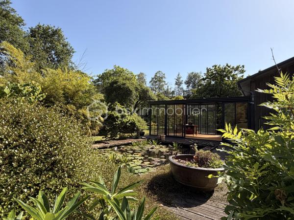 Rare à la vente, cet atelier d'artiste aménagé en maison d'habitation offre un beau potentiel à ses futurs propriétaires. 
Amoureux du bois et de la nature, ce "chalet" est fait pour vous ! Contrairement à ce que l'on pourrait penser, la structure de la maison n'est pas en bois mais en parpaing et a été enduite à la chaux. Ensuite un bardage bois a été posé. 
S'il reste aujourd'hui un atelier de peinture de 28m2 dans lequel vous pourriez aisément aussi y faire un bureau, une salle de sport, une salle de jeux ou un garage, 105m2 sont prêts à accueillir votre famille. 
Nous commencerons la visite par la pièce de vie de 45m2 qui comprend le salon-séjour et la cuisine. Une magnifique véranda chauffée "jardin d'hiver" complète cette maison, idéale pour y installer une grande table familiale ou encore un salon. 
Nous poursuivrons la visite du rez-de-chaussée avec une salle d'eau de 6m2, une chambre de 11m2. 
A l'étage, deux chambres de 12m2 au sol dont une donne accès à la "tour". 
Le mode de chauffage principal est un poêle à bois et radiateurs électriques dans la véranda et l'atelier. La maison consomme peu, le DPE est en C. 
Toutes les menuiseries sont en double vitrage. 
Coté rangement, belle surprise avec le sous-sol de 75m2, vous pourrez y stocker vélos, motos, outils et aisément un coin bricolage si vous le souhaitez. Pas de voiture possible. 
Une microstation a été installée. La toiture est en bac acier. 
Coté extérieur, vous pourrez profitez sans aucun vis à vis de la parcelle de 3300m2 partiellement close et joliment arborée et agrémentée tant par ses terrasses bois que par le bassin à poissons avec sa fontaine. 
Vous aimez le jardin, deux serres sont en place. 
La maison se situe aux portes de la Bretagne, à deux minutes de l'axe Laval-Rennes. 
Alors vous aussi vous aimez cette maison-atelier ? Appelez-moi pour plus de renseignements et peut-être fixer une visite !