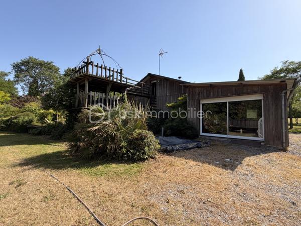 Rare à la vente, cet atelier d'artiste aménagé en maison d'habitation offre un beau potentiel à ses futurs propriétaires. 
Amoureux du bois et de la nature, ce "chalet" est fait pour vous ! Contrairement à ce que l'on pourrait penser, la structure de la maison n'est pas en bois mais en parpaing et a été enduite à la chaux. Ensuite un bardage bois a été posé. 
S'il reste aujourd'hui un atelier de peinture de 28m2 dans lequel vous pourriez aisément aussi y faire un bureau, une salle de sport, une salle de jeux ou un garage, 105m2 sont prêts à accueillir votre famille. 
Nous commencerons la visite par la pièce de vie de 45m2 qui comprend le salon-séjour et la cuisine. Une magnifique véranda chauffée "jardin d'hiver" complète cette maison, idéale pour y installer une grande table familiale ou encore un salon. 
Nous poursuivrons la visite du rez-de-chaussée avec une salle d'eau de 6m2, une chambre de 11m2. 
A l'étage, deux chambres de 12m2 au sol dont une donne accès à la "tour". 
Le mode de chauffage principal est un poêle à bois et radiateurs électriques dans la véranda et l'atelier. La maison consomme peu, le DPE est en C. 
Toutes les menuiseries sont en double vitrage. 
Coté rangement, belle surprise avec le sous-sol de 75m2, vous pourrez y stocker vélos, motos, outils et aisément un coin bricolage si vous le souhaitez. Pas de voiture possible. 
Une microstation a été installée. La toiture est en bac acier. 
Coté extérieur, vous pourrez profitez sans aucun vis à vis de la parcelle de 3300m2 partiellement close et joliment arborée et agrémentée tant par ses terrasses bois que par le bassin à poissons avec sa fontaine. 
Vous aimez le jardin, deux serres sont en place. 
La maison se situe aux portes de la Bretagne, à deux minutes de l'axe Laval-Rennes. 
Alors vous aussi vous aimez cette maison-atelier ? Appelez-moi pour plus de renseignements et peut-être fixer une visite !
