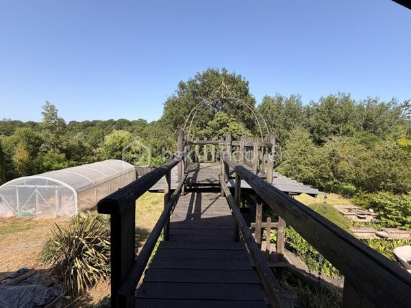 Rare à la vente, cet atelier d'artiste aménagé en maison d'habitation offre un beau potentiel à ses futurs propriétaires. 
Amoureux du bois et de la nature, ce "chalet" est fait pour vous ! Contrairement à ce que l'on pourrait penser, la structure de la maison n'est pas en bois mais en parpaing et a été enduite à la chaux. Ensuite un bardage bois a été posé. 
S'il reste aujourd'hui un atelier de peinture de 28m2 dans lequel vous pourriez aisément aussi y faire un bureau, une salle de sport, une salle de jeux ou un garage, 105m2 sont prêts à accueillir votre famille. 
Nous commencerons la visite par la pièce de vie de 45m2 qui comprend le salon-séjour et la cuisine. Une magnifique véranda chauffée "jardin d'hiver" complète cette maison, idéale pour y installer une grande table familiale ou encore un salon. 
Nous poursuivrons la visite du rez-de-chaussée avec une salle d'eau de 6m2, une chambre de 11m2. 
A l'étage, deux chambres de 12m2 au sol dont une donne accès à la "tour". 
Le mode de chauffage principal est un poêle à bois et radiateurs électriques dans la véranda et l'atelier. La maison consomme peu, le DPE est en C. 
Toutes les menuiseries sont en double vitrage. 
Coté rangement, belle surprise avec le sous-sol de 75m2, vous pourrez y stocker vélos, motos, outils et aisément un coin bricolage si vous le souhaitez. Pas de voiture possible. 
Une microstation a été installée. La toiture est en bac acier. 
Coté extérieur, vous pourrez profitez sans aucun vis à vis de la parcelle de 3300m2 partiellement close et joliment arborée et agrémentée tant par ses terrasses bois que par le bassin à poissons avec sa fontaine. 
Vous aimez le jardin, deux serres sont en place. 
La maison se situe aux portes de la Bretagne, à deux minutes de l'axe Laval-Rennes. 
Alors vous aussi vous aimez cette maison-atelier ? Appelez-moi pour plus de renseignements et peut-être fixer une visite !