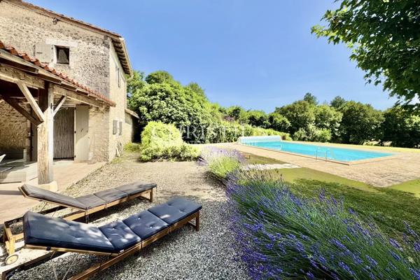 Maison de caractère avec grange, piscine et jardin paysager dans un hameau paisible