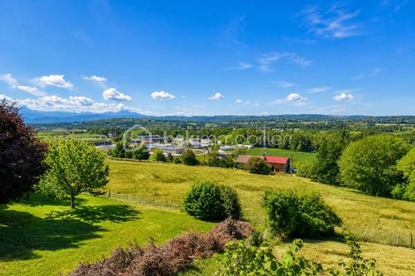 Vous cherchez une maison baignée de lumière, avec une vraie vue sur les montagnes — et la tranquillité d'un secteur calme, sans être loin de tout ? Cette maison est faite pour vous.

Implantée à moins d'un kilomètre du centre du village de Saint-Genix-sur-Guiers, cette maison bénéficie d'une situation idéale : commerces, écoles et services à pied, et pourtant aucune nuisance sonore. À seulement 25 minutes de Chambéry.

A l'extérieur la parcelle de plus de 1200 m², bien exposée, offre suffisamment d'espace pour créer une piscine et profiter pleinement des beaux jours, avec les montagnes en toile de fond.

Le rez-de-chaussée s'articule autour d'une grande et belle pièce de vie agrémentée d'une cheminée — le cœur de la maison — complétée par une cuisine séparée. Une chambre et une salle de bain au RDC permettent d'envisager une vie entièrement en plain-pied.

A l'étage : trois chambres lumineuses, et une mezzanine aménagée en espace bureau avec une vue dégagée sur les sommets environnants. Un endroit  idéal pour travailler, lire ou simplement profiter du panorama.

Le sous-sol complet est un véritable atout : garage, coin buanderie avec évier, et une grande pièce indépendante de 33 m² aux multiples possibilités — studio, bureau, salle de sport, salle de jeux, espace créatif... Une surface rare qui offre une vraie flexibilité d'usage.

Assainissement collectif. Prévoir budget de rénovation énergétique (audit disponible).