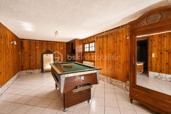 Vous cherchez une maison baignée de lumière, avec une vraie vue sur les montagnes — et la tranquillité d'un secteur calme, sans être loin de tout ? Cette maison est faite pour vous.

Implantée à moins d'un kilomètre du centre du village de Saint-Genix-sur-Guiers, cette maison bénéficie d'une situation idéale : commerces, écoles et services à pied, et pourtant aucune nuisance sonore. À seulement 25 minutes de Chambéry.

A l'extérieur la parcelle de plus de 1200 m², bien exposée, offre suffisamment d'espace pour créer une piscine et profiter pleinement des beaux jours, avec les montagnes en toile de fond.

Le rez-de-chaussée s'articule autour d'une grande et belle pièce de vie agrémentée d'une cheminée — le cœur de la maison — complétée par une cuisine séparée. Une chambre et une salle de bain au RDC permettent d'envisager une vie entièrement en plain-pied.

A l'étage : trois chambres lumineuses, et une mezzanine aménagée en espace bureau avec une vue dégagée sur les sommets environnants. Un endroit  idéal pour travailler, lire ou simplement profiter du panorama.

Le sous-sol complet est un véritable atout : garage, coin buanderie avec évier, et une grande pièce indépendante de 33 m² aux multiples possibilités — studio, bureau, salle de sport, salle de jeux, espace créatif... Une surface rare qui offre une vraie flexibilité d'usage.

Assainissement collectif. Prévoir budget de rénovation énergétique (audit disponible).