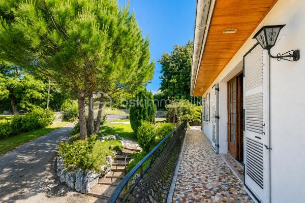 Vous cherchez une maison baignée de lumière, avec une vraie vue sur les montagnes — et la tranquillité d'un secteur calme, sans être loin de tout ? Cette maison est faite pour vous.

Implantée à moins d'un kilomètre du centre du village de Saint-Genix-sur-Guiers, cette maison bénéficie d'une situation idéale : commerces, écoles et services à pied, et pourtant aucune nuisance sonore. À seulement 25 minutes de Chambéry.

A l'extérieur la parcelle de plus de 1200 m², bien exposée, offre suffisamment d'espace pour créer une piscine et profiter pleinement des beaux jours, avec les montagnes en toile de fond.

Le rez-de-chaussée s'articule autour d'une grande et belle pièce de vie agrémentée d'une cheminée — le cœur de la maison — complétée par une cuisine séparée. Une chambre et une salle de bain au RDC permettent d'envisager une vie entièrement en plain-pied.

A l'étage : trois chambres lumineuses, et une mezzanine aménagée en espace bureau avec une vue dégagée sur les sommets environnants. Un endroit  idéal pour travailler, lire ou simplement profiter du panorama.

Le sous-sol complet est un véritable atout : garage, coin buanderie avec évier, et une grande pièce indépendante de 33 m² aux multiples possibilités — studio, bureau, salle de sport, salle de jeux, espace créatif... Une surface rare qui offre une vraie flexibilité d'usage.

Assainissement collectif. Prévoir budget de rénovation énergétique (audit disponible).