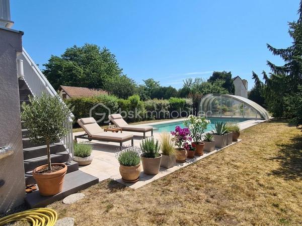 Située dans un quartier calme, à proximité immédiate des écoles, des commerces et des principaux axes routiers, cette agréable maison offre de beaux volumes et de nombreuses possibilités d'aménagement. Elle conviendra aussi bien à une famille qu'à une personne souhaitant exercer une activité professionnelle à domicile.

Dès l'entrée, vous découvrirez un sas, puis une entrée accueillante. La cuisine équipée, indépendante, donne accès à un balcon-terrasse avec vue sur une magnifique piscine, utilisable toute l'année grâce à son abri télescopique Voroka avec rails encastrés.

Le rez-de-chaussée comprend également un WC indépendant, un espace de rangement, une pièce polyvalente pouvant faire office de bureau, salle de jeux ou chambre d'appoint, ainsi qu'un vaste séjour lumineux agrémenté d'une cheminée.
À l'étage, vous trouverez une chambre, un toilette indépendant, une salle de bains et une grande seconde chambre, facilement transformable en deux chambres, conformément à sa configuration d'origine.

Le sous-sol est particulièrement fonctionnel avec un garage, de nombreux espaces de rangement, une cave, une buanderie avec salle d'eau et WC, ainsi qu'un local technique équipé d'un WC et d'une douche, idéal après les baignades ou les séances bien-être.
Vous profiterez également d'un véritable espace bien-être comprenant un sauna infrarouge, un spa et une pièce pouvant être aménagée en salle de sport, salle de soins ou selon vos envies.
Enfin, une dépendance indépendante offre un espace idéal pour une activité professionnelle, un cabinet (bien-être, esthétique, profession libérale…), un atelier ou le télétravail.

Les atouts :
Quartier calme.
Espaces.
Proximité des écoles, commerces et axes routiers.
Piscine couverte par un dôme, utilisable toute l'année.
Cheminée.
Espace bien-être avec sauna et spa.
Dépendance idéale pour une activité professionnelle ou le télétravail.

Nombreuses possibilités d'aménagement selon vos besoins.
Une maison aux multiples atouts, offrant un cadre de vie agréable et un fort potentiel pour concilier vie familiale et activité professionnelle.