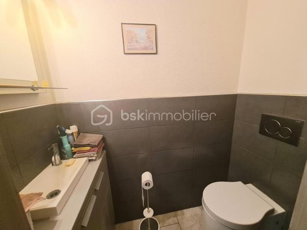 Située dans un quartier calme, à proximité immédiate des écoles, des commerces et des principaux axes routiers, cette agréable maison offre de beaux volumes et de nombreuses possibilités d'aménagement. Elle conviendra aussi bien à une famille qu'à une personne souhaitant exercer une activité professionnelle à domicile.

Dès l'entrée, vous découvrirez un sas, puis une entrée accueillante. La cuisine équipée, indépendante, donne accès à un balcon-terrasse avec vue sur une magnifique piscine, utilisable toute l'année grâce à son abri télescopique Voroka avec rails encastrés.

Le rez-de-chaussée comprend également un WC indépendant, un espace de rangement, une pièce polyvalente pouvant faire office de bureau, salle de jeux ou chambre d'appoint, ainsi qu'un vaste séjour lumineux agrémenté d'une cheminée.
À l'étage, vous trouverez une chambre, un toilette indépendant, une salle de bains et une grande seconde chambre, facilement transformable en deux chambres, conformément à sa configuration d'origine.

Le sous-sol est particulièrement fonctionnel avec un garage, de nombreux espaces de rangement, une cave, une buanderie avec salle d'eau et WC, ainsi qu'un local technique équipé d'un WC et d'une douche, idéal après les baignades ou les séances bien-être.
Vous profiterez également d'un véritable espace bien-être comprenant un sauna infrarouge, un spa et une pièce pouvant être aménagée en salle de sport, salle de soins ou selon vos envies.
Enfin, une dépendance indépendante offre un espace idéal pour une activité professionnelle, un cabinet (bien-être, esthétique, profession libérale…), un atelier ou le télétravail.

Les atouts :
Quartier calme.
Espaces.
Proximité des écoles, commerces et axes routiers.
Piscine couverte par un dôme, utilisable toute l'année.
Cheminée.
Espace bien-être avec sauna et spa.
Dépendance idéale pour une activité professionnelle ou le télétravail.

Nombreuses possibilités d'aménagement selon vos besoins.
Une maison aux multiples atouts, offrant un cadre de vie agréable et un fort potentiel pour concilier vie familiale et activité professionnelle.