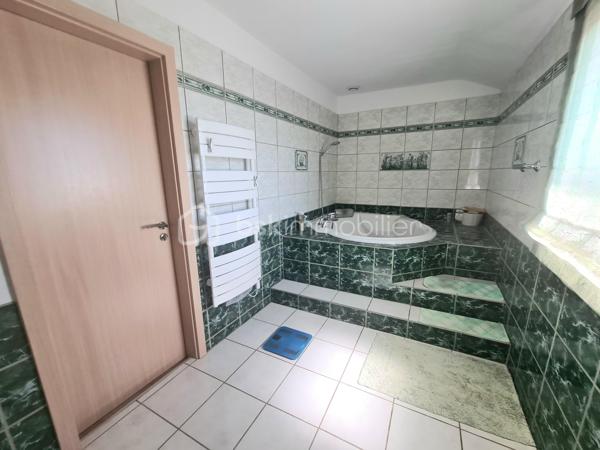 Située dans un quartier calme, à proximité immédiate des écoles, des commerces et des principaux axes routiers, cette agréable maison offre de beaux volumes et de nombreuses possibilités d'aménagement. Elle conviendra aussi bien à une famille qu'à une personne souhaitant exercer une activité professionnelle à domicile.

Dès l'entrée, vous découvrirez un sas, puis une entrée accueillante. La cuisine équipée, indépendante, donne accès à un balcon-terrasse avec vue sur une magnifique piscine, utilisable toute l'année grâce à son abri télescopique Voroka avec rails encastrés.

Le rez-de-chaussée comprend également un WC indépendant, un espace de rangement, une pièce polyvalente pouvant faire office de bureau, salle de jeux ou chambre d'appoint, ainsi qu'un vaste séjour lumineux agrémenté d'une cheminée.
À l'étage, vous trouverez une chambre, un toilette indépendant, une salle de bains et une grande seconde chambre, facilement transformable en deux chambres, conformément à sa configuration d'origine.

Le sous-sol est particulièrement fonctionnel avec un garage, de nombreux espaces de rangement, une cave, une buanderie avec salle d'eau et WC, ainsi qu'un local technique équipé d'un WC et d'une douche, idéal après les baignades ou les séances bien-être.
Vous profiterez également d'un véritable espace bien-être comprenant un sauna infrarouge, un spa et une pièce pouvant être aménagée en salle de sport, salle de soins ou selon vos envies.
Enfin, une dépendance indépendante offre un espace idéal pour une activité professionnelle, un cabinet (bien-être, esthétique, profession libérale…), un atelier ou le télétravail.

Les atouts :
Quartier calme.
Espaces.
Proximité des écoles, commerces et axes routiers.
Piscine couverte par un dôme, utilisable toute l'année.
Cheminée.
Espace bien-être avec sauna et spa.
Dépendance idéale pour une activité professionnelle ou le télétravail.

Nombreuses possibilités d'aménagement selon vos besoins.
Une maison aux multiples atouts, offrant un cadre de vie agréable et un fort potentiel pour concilier vie familiale et activité professionnelle.