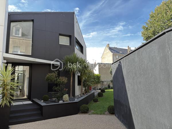 Confidentielle, contemporaine et résolument singulière.

À l’abri des regards, derrière une discrète porte cochère, se dévoile une maison d’architecte de 151 m², nichée au cœur de l’un des secteurs les plus recherchés de Tours, dans le très prisé quartier des Prébendes.
À quelques pas de l’hypercentre, cette adresse rare conjugue avec élégance intimité, architecture contemporaine et proximité immédiate de la vie tourangelle.

Dès l’entrée, la générosité des volumes et la hauteur sous plafond révèlent une conception pensée autour de la lumière et de la fluidité. La maison s’articule autour d’un remarquable patio végétalisé, véritable cœur architectural du lieu.

Le vaste séjour constitue la pièce maîtresse de la maison. Baigné de lumière naturelle par une élégante verrière et de larges baies vitrées, il offre une sensation remarquable d’espace et d’ouverture sur la végétation. La cuisine, parfaitement intégrée, prolonge cet ensemble dans une esthétique sobre et contemporaine.

Un salon plus intime vient compléter cet espace de réception, créant une atmosphère chaleureuse et raffinée.

Ici, chaque détail a été pensé dans un souci de confort et de discrétion. La maison bénéficie notamment d’un système audio Sonos intégré dans chaque pièce, permettant de prolonger l’expérience sonore dans l’ensemble de la propriété.

À l’étage, l’architecture se poursuit avec la même exigence. L’escalier ouvert préserve les perspectives et accompagne une belle mezzanine surplombant le séjour. Depuis celle-ci, les vues traversantes sur le patio et le jardin renforcent cette sensation de continuité entre intérieur et extérieur.
La chambre dispose d’un dressing aménagé et profite d’un environnement particulièrement préservé. Une élégante salle de bains complète cet étage avec douche, baignoire et WC.

À l’extérieur, le jardin paysager se découvre comme un prolongement naturel de la maison. Une sélection d’essences végétales compose un écrin intime et apaisant, tandis que la terrasse en bois invite aux longues soirées d’été et aux moments de convivialité.
L’adresse réserve enfin un privilège particulièrement recherché aux Prébendes : un porche couvert permettant le stationnement de deux véhicules.

UNE ADRESSE. UNE ARCHITECTURE. UNE ATMOSPHÈRE.

Plus qu’une maison, cette propriété offre une véritable expérience de vie : celle d’un lieu confidentiel où la lumière, la végétation et les volumes dialoguent en permanence.
Une architecture contemporaine d’exception, au caractère affirmé, dans l’un des quartiers les plus emblématiques de Tours.
Un bien rare, destiné aux amateurs d’architecture, de discrétion et d’adresses privilégiées.

Points forts : 
-Faible consommation d'énergie
-Une mezzanine pouvant faire office de chambre supplémentaire 
-Cuisine tout équipée 
-La maison peut être vendue meublée