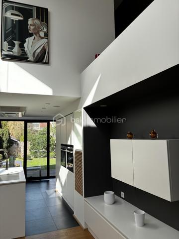 Confidentielle, contemporaine et résolument singulière.

À l’abri des regards, derrière une discrète porte cochère, se dévoile une maison d’architecte de 151 m², nichée au cœur de l’un des secteurs les plus recherchés de Tours, dans le très prisé quartier des Prébendes.
À quelques pas de l’hypercentre, cette adresse rare conjugue avec élégance intimité, architecture contemporaine et proximité immédiate de la vie tourangelle.

Dès l’entrée, la générosité des volumes et la hauteur sous plafond révèlent une conception pensée autour de la lumière et de la fluidité. La maison s’articule autour d’un remarquable patio végétalisé, véritable cœur architectural du lieu.

Le vaste séjour constitue la pièce maîtresse de la maison. Baigné de lumière naturelle par une élégante verrière et de larges baies vitrées, il offre une sensation remarquable d’espace et d’ouverture sur la végétation. La cuisine, parfaitement intégrée, prolonge cet ensemble dans une esthétique sobre et contemporaine.

Un salon plus intime vient compléter cet espace de réception, créant une atmosphère chaleureuse et raffinée.

Ici, chaque détail a été pensé dans un souci de confort et de discrétion. La maison bénéficie notamment d’un système audio Sonos intégré dans chaque pièce, permettant de prolonger l’expérience sonore dans l’ensemble de la propriété.

À l’étage, l’architecture se poursuit avec la même exigence. L’escalier ouvert préserve les perspectives et accompagne une belle mezzanine surplombant le séjour. Depuis celle-ci, les vues traversantes sur le patio et le jardin renforcent cette sensation de continuité entre intérieur et extérieur.
La chambre dispose d’un dressing aménagé et profite d’un environnement particulièrement préservé. Une élégante salle de bains complète cet étage avec douche, baignoire et WC.

À l’extérieur, le jardin paysager se découvre comme un prolongement naturel de la maison. Une sélection d’essences végétales compose un écrin intime et apaisant, tandis que la terrasse en bois invite aux longues soirées d’été et aux moments de convivialité.
L’adresse réserve enfin un privilège particulièrement recherché aux Prébendes : un porche couvert permettant le stationnement de deux véhicules.

UNE ADRESSE. UNE ARCHITECTURE. UNE ATMOSPHÈRE.

Plus qu’une maison, cette propriété offre une véritable expérience de vie : celle d’un lieu confidentiel où la lumière, la végétation et les volumes dialoguent en permanence.
Une architecture contemporaine d’exception, au caractère affirmé, dans l’un des quartiers les plus emblématiques de Tours.
Un bien rare, destiné aux amateurs d’architecture, de discrétion et d’adresses privilégiées.

Points forts : 
-Faible consommation d'énergie
-Une mezzanine pouvant faire office de chambre supplémentaire 
-Cuisine tout équipée 
-La maison peut être vendue meublée