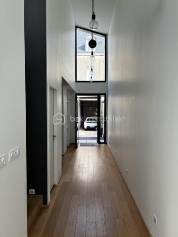 Confidentielle, contemporaine et résolument singulière.

À l’abri des regards, derrière une discrète porte cochère, se dévoile une maison d’architecte de 151 m², nichée au cœur de l’un des secteurs les plus recherchés de Tours, dans le très prisé quartier des Prébendes.
À quelques pas de l’hypercentre, cette adresse rare conjugue avec élégance intimité, architecture contemporaine et proximité immédiate de la vie tourangelle.

Dès l’entrée, la générosité des volumes et la hauteur sous plafond révèlent une conception pensée autour de la lumière et de la fluidité. La maison s’articule autour d’un remarquable patio végétalisé, véritable cœur architectural du lieu.

Le vaste séjour constitue la pièce maîtresse de la maison. Baigné de lumière naturelle par une élégante verrière et de larges baies vitrées, il offre une sensation remarquable d’espace et d’ouverture sur la végétation. La cuisine, parfaitement intégrée, prolonge cet ensemble dans une esthétique sobre et contemporaine.

Un salon plus intime vient compléter cet espace de réception, créant une atmosphère chaleureuse et raffinée.

Ici, chaque détail a été pensé dans un souci de confort et de discrétion. La maison bénéficie notamment d’un système audio Sonos intégré dans chaque pièce, permettant de prolonger l’expérience sonore dans l’ensemble de la propriété.

À l’étage, l’architecture se poursuit avec la même exigence. L’escalier ouvert préserve les perspectives et accompagne une belle mezzanine surplombant le séjour. Depuis celle-ci, les vues traversantes sur le patio et le jardin renforcent cette sensation de continuité entre intérieur et extérieur.
La chambre dispose d’un dressing aménagé et profite d’un environnement particulièrement préservé. Une élégante salle de bains complète cet étage avec douche, baignoire et WC.

À l’extérieur, le jardin paysager se découvre comme un prolongement naturel de la maison. Une sélection d’essences végétales compose un écrin intime et apaisant, tandis que la terrasse en bois invite aux longues soirées d’été et aux moments de convivialité.
L’adresse réserve enfin un privilège particulièrement recherché aux Prébendes : un porche couvert permettant le stationnement de deux véhicules.

UNE ADRESSE. UNE ARCHITECTURE. UNE ATMOSPHÈRE.

Plus qu’une maison, cette propriété offre une véritable expérience de vie : celle d’un lieu confidentiel où la lumière, la végétation et les volumes dialoguent en permanence.
Une architecture contemporaine d’exception, au caractère affirmé, dans l’un des quartiers les plus emblématiques de Tours.
Un bien rare, destiné aux amateurs d’architecture, de discrétion et d’adresses privilégiées.

Points forts : 
-Faible consommation d'énergie
-Une mezzanine pouvant faire office de chambre supplémentaire 
-Cuisine tout équipée 
-La maison peut être vendue meublée