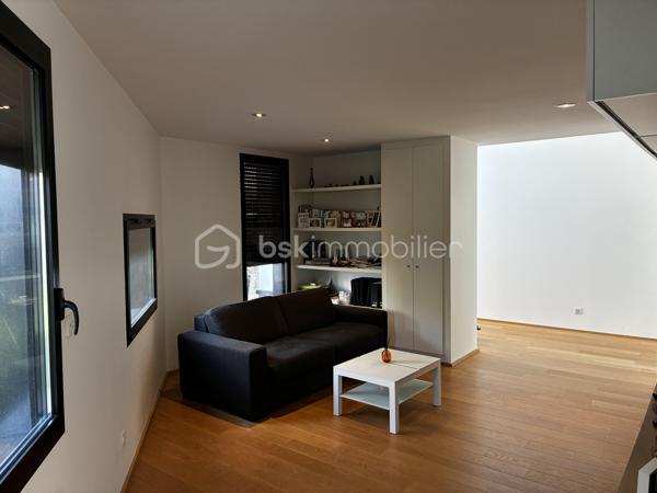 Confidentielle, contemporaine et résolument singulière.

À l’abri des regards, derrière une discrète porte cochère, se dévoile une maison d’architecte de 151 m², nichée au cœur de l’un des secteurs les plus recherchés de Tours, dans le très prisé quartier des Prébendes.
À quelques pas de l’hypercentre, cette adresse rare conjugue avec élégance intimité, architecture contemporaine et proximité immédiate de la vie tourangelle.

Dès l’entrée, la générosité des volumes et la hauteur sous plafond révèlent une conception pensée autour de la lumière et de la fluidité. La maison s’articule autour d’un remarquable patio végétalisé, véritable cœur architectural du lieu.

Le vaste séjour constitue la pièce maîtresse de la maison. Baigné de lumière naturelle par une élégante verrière et de larges baies vitrées, il offre une sensation remarquable d’espace et d’ouverture sur la végétation. La cuisine, parfaitement intégrée, prolonge cet ensemble dans une esthétique sobre et contemporaine.

Un salon plus intime vient compléter cet espace de réception, créant une atmosphère chaleureuse et raffinée.

Ici, chaque détail a été pensé dans un souci de confort et de discrétion. La maison bénéficie notamment d’un système audio Sonos intégré dans chaque pièce, permettant de prolonger l’expérience sonore dans l’ensemble de la propriété.

À l’étage, l’architecture se poursuit avec la même exigence. L’escalier ouvert préserve les perspectives et accompagne une belle mezzanine surplombant le séjour. Depuis celle-ci, les vues traversantes sur le patio et le jardin renforcent cette sensation de continuité entre intérieur et extérieur.
La chambre dispose d’un dressing aménagé et profite d’un environnement particulièrement préservé. Une élégante salle de bains complète cet étage avec douche, baignoire et WC.

À l’extérieur, le jardin paysager se découvre comme un prolongement naturel de la maison. Une sélection d’essences végétales compose un écrin intime et apaisant, tandis que la terrasse en bois invite aux longues soirées d’été et aux moments de convivialité.
L’adresse réserve enfin un privilège particulièrement recherché aux Prébendes : un porche couvert permettant le stationnement de deux véhicules.

UNE ADRESSE. UNE ARCHITECTURE. UNE ATMOSPHÈRE.

Plus qu’une maison, cette propriété offre une véritable expérience de vie : celle d’un lieu confidentiel où la lumière, la végétation et les volumes dialoguent en permanence.
Une architecture contemporaine d’exception, au caractère affirmé, dans l’un des quartiers les plus emblématiques de Tours.
Un bien rare, destiné aux amateurs d’architecture, de discrétion et d’adresses privilégiées.

Points forts : 
-Faible consommation d'énergie
-Une mezzanine pouvant faire office de chambre supplémentaire 
-Cuisine tout équipée 
-La maison peut être vendue meublée