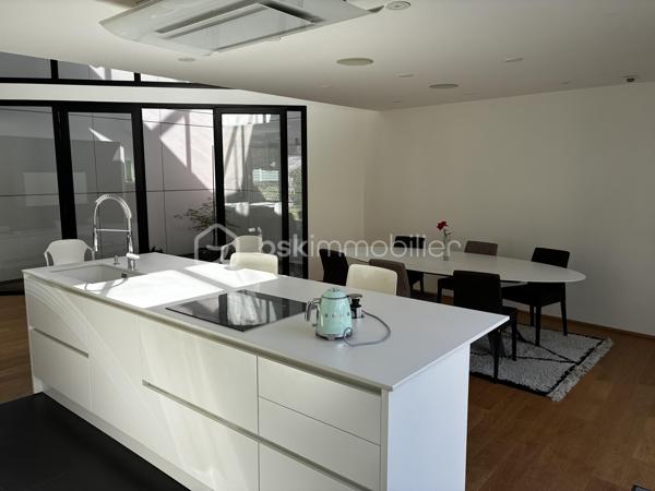 Confidentielle, contemporaine et résolument singulière.

À l’abri des regards, derrière une discrète porte cochère, se dévoile une maison d’architecte de 151 m², nichée au cœur de l’un des secteurs les plus recherchés de Tours, dans le très prisé quartier des Prébendes.
À quelques pas de l’hypercentre, cette adresse rare conjugue avec élégance intimité, architecture contemporaine et proximité immédiate de la vie tourangelle.

Dès l’entrée, la générosité des volumes et la hauteur sous plafond révèlent une conception pensée autour de la lumière et de la fluidité. La maison s’articule autour d’un remarquable patio végétalisé, véritable cœur architectural du lieu.

Le vaste séjour constitue la pièce maîtresse de la maison. Baigné de lumière naturelle par une élégante verrière et de larges baies vitrées, il offre une sensation remarquable d’espace et d’ouverture sur la végétation. La cuisine, parfaitement intégrée, prolonge cet ensemble dans une esthétique sobre et contemporaine.

Un salon plus intime vient compléter cet espace de réception, créant une atmosphère chaleureuse et raffinée.

Ici, chaque détail a été pensé dans un souci de confort et de discrétion. La maison bénéficie notamment d’un système audio Sonos intégré dans chaque pièce, permettant de prolonger l’expérience sonore dans l’ensemble de la propriété.

À l’étage, l’architecture se poursuit avec la même exigence. L’escalier ouvert préserve les perspectives et accompagne une belle mezzanine surplombant le séjour. Depuis celle-ci, les vues traversantes sur le patio et le jardin renforcent cette sensation de continuité entre intérieur et extérieur.
La chambre dispose d’un dressing aménagé et profite d’un environnement particulièrement préservé. Une élégante salle de bains complète cet étage avec douche, baignoire et WC.

À l’extérieur, le jardin paysager se découvre comme un prolongement naturel de la maison. Une sélection d’essences végétales compose un écrin intime et apaisant, tandis que la terrasse en bois invite aux longues soirées d’été et aux moments de convivialité.
L’adresse réserve enfin un privilège particulièrement recherché aux Prébendes : un porche couvert permettant le stationnement de deux véhicules.

UNE ADRESSE. UNE ARCHITECTURE. UNE ATMOSPHÈRE.

Plus qu’une maison, cette propriété offre une véritable expérience de vie : celle d’un lieu confidentiel où la lumière, la végétation et les volumes dialoguent en permanence.
Une architecture contemporaine d’exception, au caractère affirmé, dans l’un des quartiers les plus emblématiques de Tours.
Un bien rare, destiné aux amateurs d’architecture, de discrétion et d’adresses privilégiées.

Points forts : 
-Faible consommation d'énergie
-Une mezzanine pouvant faire office de chambre supplémentaire 
-Cuisine tout équipée 
-La maison peut être vendue meublée