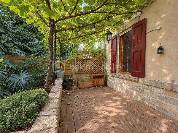 Une terrasse à l’ombre de la vigne, la chaleur d’un poêle à bois, les commerces à proximité… Située dans une rue calme dans le quartier des Rotondes, à deux pas du quartier des Sources, cette maison réunit le charme d’un lieu accueillant et les atouts d’une adresse pratique, à une dizaine de minutes à pied des remparts.

Avec environ 68 m², complétés par une véranda de 7 m², son agencement procure une agréable sensation d’espace. Au rez-de-chaussée, la grande pièce de vie traversante associe salon et cuisine ouverte équipée : un espace convivial où la lumière circule d’un côté à l’autre de la maison.

L’escalier en bois mène à deux belles chambres avec parquet massif et à une grande salle d’eau rénovée en 2024, comprenant une douche et un WC. Un second WC se situe au rez-de-chaussée, dans la véranda, qui peut aussi accueillir la buanderie.

À l’extérieur, le jardin avant et sa terrasse en bois sous la vigne offrent un coin agréable pour les repas ou les pauses à l’ombre. À l’arrière, le patio et son abri apportent un espace détente supplémentaire, et permet de ranger outils et bois.

La maison dispose d’atouts concrets pour un confort économe : un poêle à bois labellisé Flamme Verte, fenêtres en double vitrage, et une isolation des combles refaite récemment. Un système de ventilation efficace contribue au renouvellement de l’air intérieur.

Le quotidien peut largement s’organiser à pied : nombreux commerces à proximité immédiate, marché du mardi matin, arrêt de bus Rotondes à environ 100 mètres et remparts accessibles en une dizaine de minutes. Le stationnement est aisé dans le secteur, avec des places dans la rue et deux parkings à proximité.

Une maison chaleureuse et bien pensée, pour profiter du calme tout en restant proche de la vie avignonnaise.

Professionnels de l'immobilier: Si vous accompagnez des acquéreurs dans leur recherche, et que vous pensez que ce bien pourrait répondre à leurs besoins, n'hésitez pas à appeler.

--------------------------