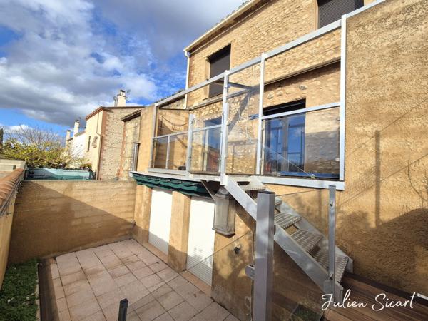 Maison de village avec garage et extérieur.