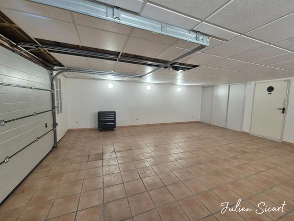 Maison de village avec garage et extérieur.